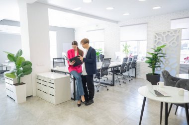 Meslektaşlar belgeli bir klasöre bakar ve iş konularını tartışırlar