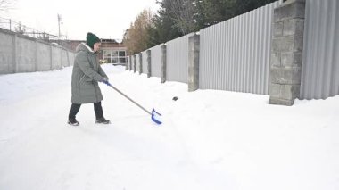 Kar kürüyen Kafkasyalı yaşlı kadın