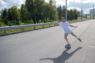 Beyaz şortlu kadın paten kayıyor.