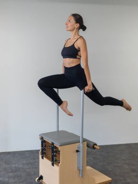 Beyaz kadın klasik sandalyede pilates yapıyor.