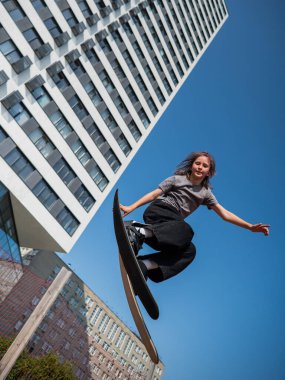 Kız trambolinde kayak numarası yapıyor.