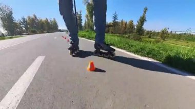 Beyaz bir adam slalom pistinde paten kayıyor.