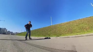 Beyaz bir adam hızla paten kayar.