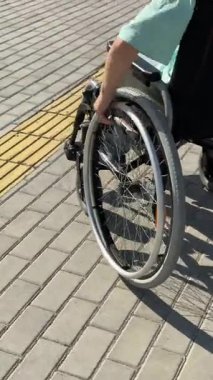 Tekerlekli sandalyedeki bir kadının ellerine yakından bakın.