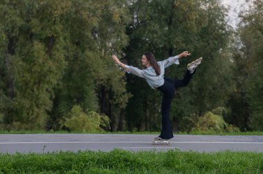 Beyaz kadın parkta paten kayıyor.