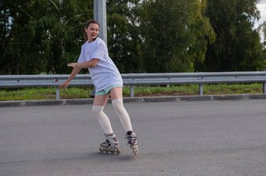 Beyaz şortlu kadın paten kayıyor.