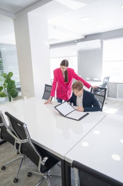 Beyaz kadın astlarına talimat veriyor.