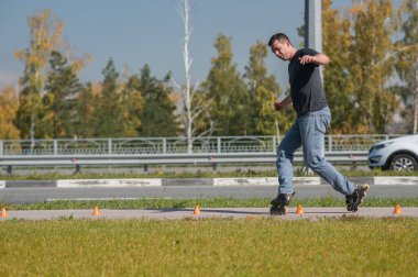 Beyaz bir adam slalom pistinde paten kayıyor.