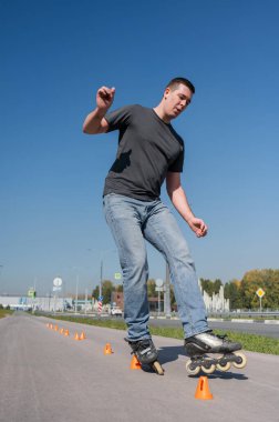 Beyaz bir adam slalom pistinde paten kayıyor.