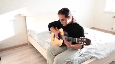 Genç adam akustik gitar çalıyor. Parmak Biçimi