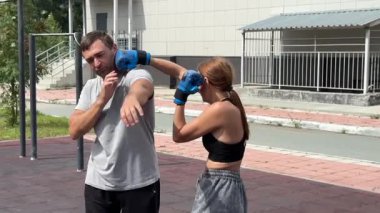 Erkek ve kadın dışarıda boks yapıyor.