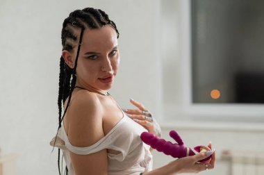 Caucasian woman holding a pink dildo