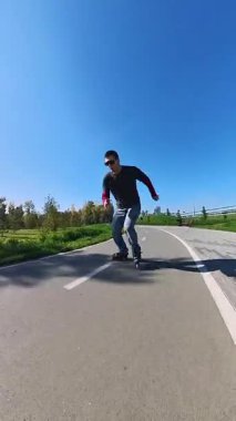 Beyaz bir adam paten üzerinde numaralar yapıyor.