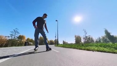 Beyaz bir adam paten üzerinde numaralar yapıyor.