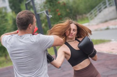 Erkek ve kadın dışarıda idman yapıyor. Boks dersi