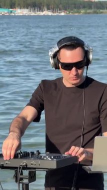 Beyaz adam plajda DJ olarak çalışıyor.