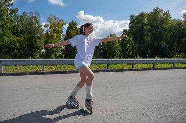 Beyaz şortlu kadın paten kayıyor.