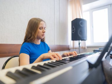 Beyaz kadın elektrikli piyano çalıyor.