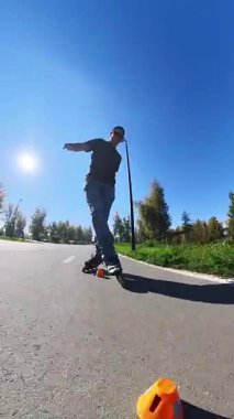 Beyaz bir adam slalom pistinde paten kayıyor.