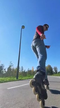 Beyaz bir adam paten üzerinde numaralar yapıyor.