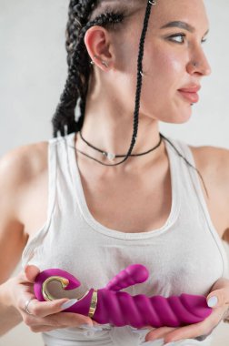 Caucasian woman holding a pink dildo