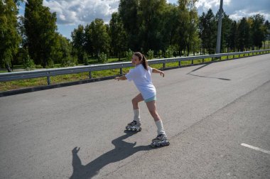 Beyaz şortlu kadın paten kayıyor.