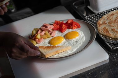 Şef kafede sahanda yumurta servis ediyor.