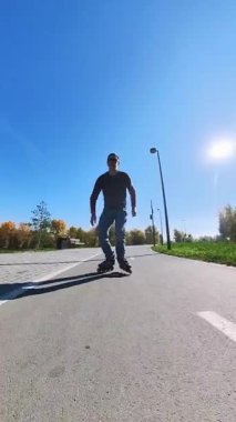 Beyaz bir adam paten üzerinde numaralar yapıyor.