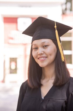 Mezuniyet elbisesi içindeki mutlu Asyalı kadın.