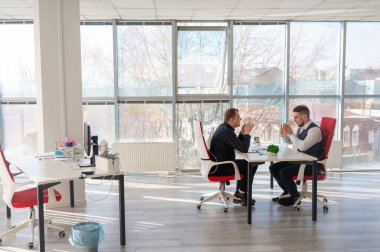 İki beyaz adam bir iş toplantısında iletişim kuruyor.