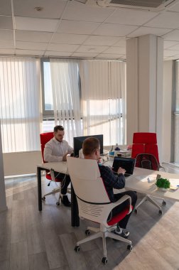 Bir ofiste çalışan iki beyaz adam.