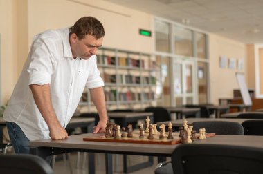 Beyaz adam satranç hamlesi düşünüyor.