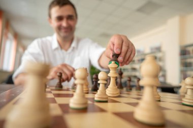 Beyaz adam satranç hamlesi düşünüyor.