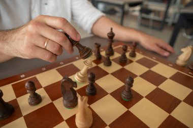 Orta yaşlı beyaz bir adamın satranç oynaması yakındır.