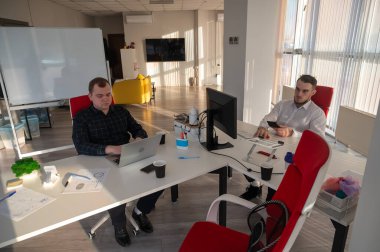 Bir ofiste çalışan iki beyaz adam.