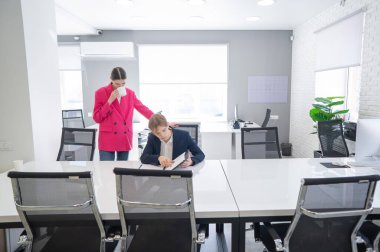 Beyaz kadın astlarına talimat veriyor.