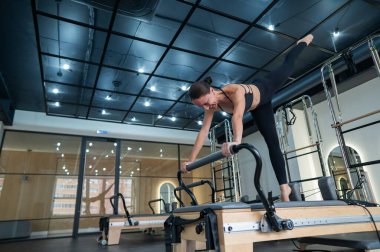 Kafkas kadın yenilikçi makineler üzerinde egzersiz yapıyor.