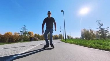 Beyaz bir adam paten üzerinde numaralar yapıyor.