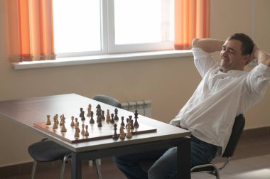 Beyaz adam satranç hamlesi düşünüyor.