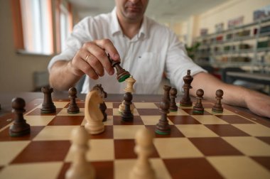 Beyaz adam satranç hamlesi düşünüyor.