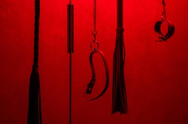 BDSM oyuncakları koleksiyonu, kırmızı ışıkta kırbaçlar
