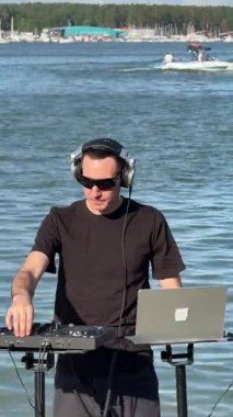 Beyaz adam plajda DJ olarak çalışıyor.