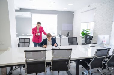 Beyaz kadın astlarına talimat veriyor.