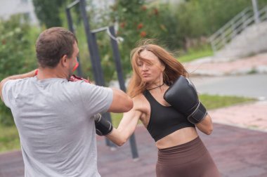 Erkek ve kadın dışarıda idman yapıyor. Boks dersi