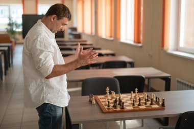 Beyaz adam satranç hamlesi düşünüyor.