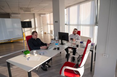 Bir ofiste çalışan iki beyaz adam.