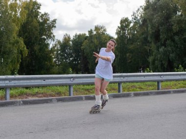 Beyaz şortlu kadın paten kayıyor.