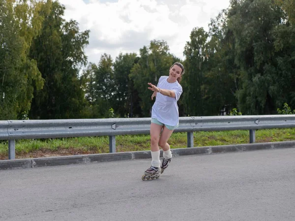 Beyaz şortlu kadın paten kayıyor.