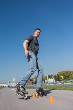 Beyaz bir adam slalom pistinde paten kayıyor.