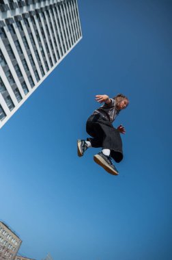 Bir kız trambolinde jimnastik yapıyor.